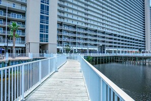 Un hôtel situé au bord de l’eau, avec une longue promenade en bois qui mène à une marina.