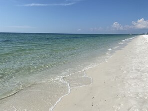 Ein Strand mit klarem Wasser und sandigem Ufer.
