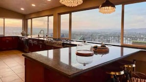 Una cucina moderna con ampie finestre, un'isola centrale e vista sulla città.