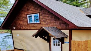 A wooden cabin with a small porch, a door, and a window. - Lakefront Muskoka Good View cottage (Gravenhurst)