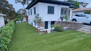 A modern two-story house with a well-maintained lawn, a small garden, and a car parked in the driveway. - Maison Individuelle Entre Océan et Forêt (Anglet)
