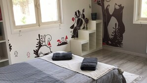 A bedroom with a bed, a window, and wall decorations including a tree and a bear. - Maison Individuelle Entre Océan et Forêt (Anglet)