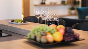 A dining area with a wooden table, a fruit platter, and three pendant lights. - Villa Velebita (Zadar)