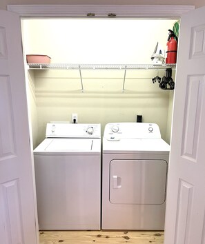 Compact laundry facilities with two washing machines and a dryer.