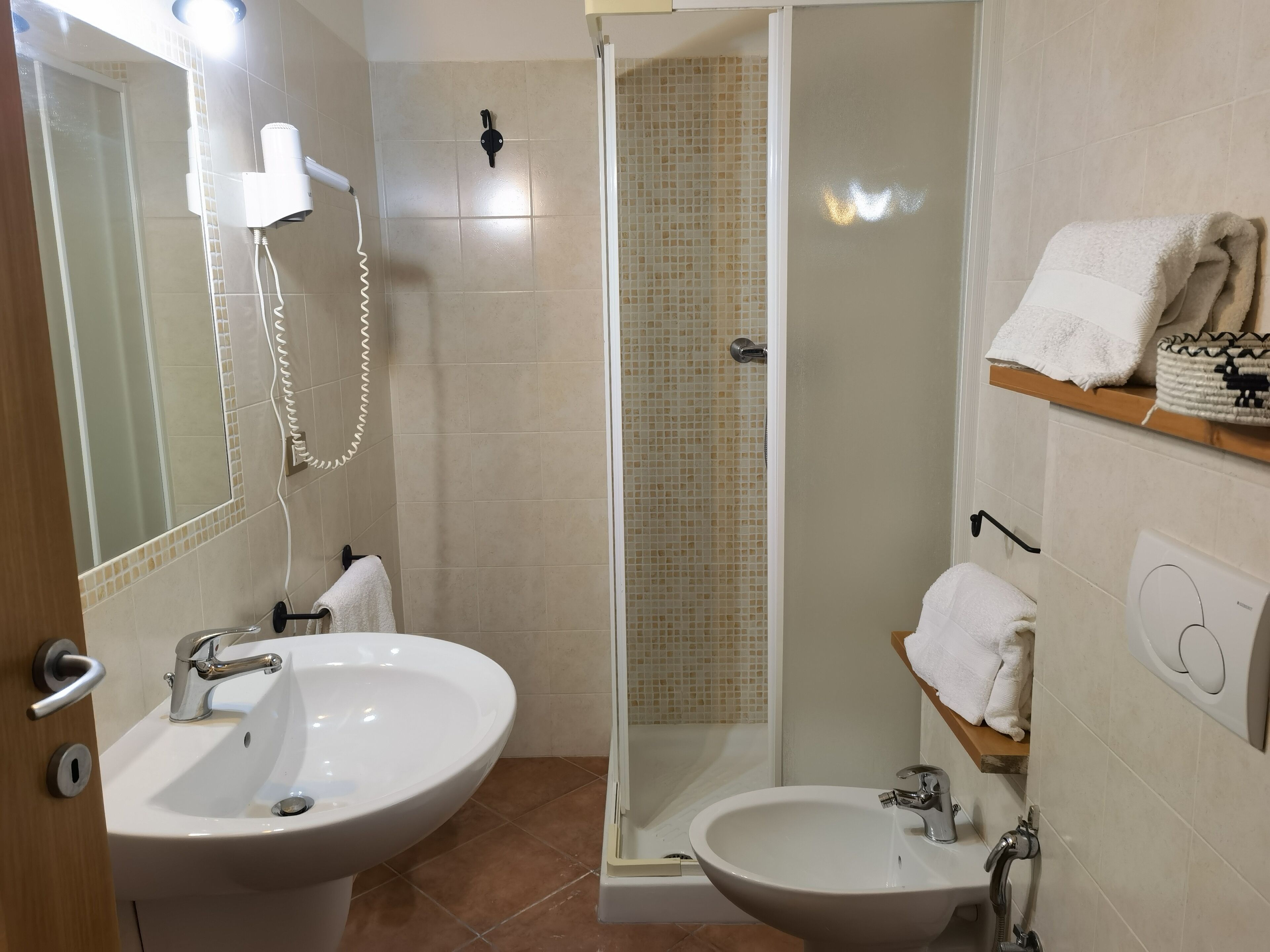 Ein Badezimmer mit zwei Waschbecken, einer Dusche und einer gläsernen Duschkabine.