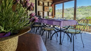 A dining area with a table set for six, surrounded by metal chairs. - la corte degli ulivi (Tresnuraghes)