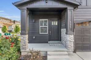 A modern house with a dark gray exterior, a stone accent wall, and a garage door number 585.
