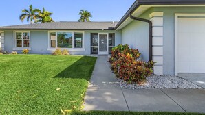 A modern two-story house with a well-maintained lawn, a driveway, and a garage.