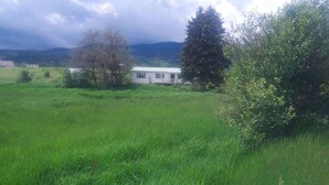 A house in a grassy field with a cloudy sky. - A hunter's/Getaway Paradise (Council)