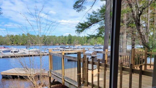 A wooden deck with a view of a marina and boats.