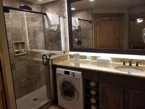 Een douche, een bubbelbad, handdoeken, zeep
