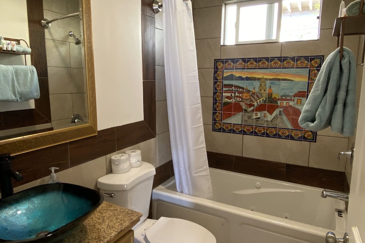 Ein Badezimmer mit Waschbecken, Toilette, Badewanne und Duschvorhang.