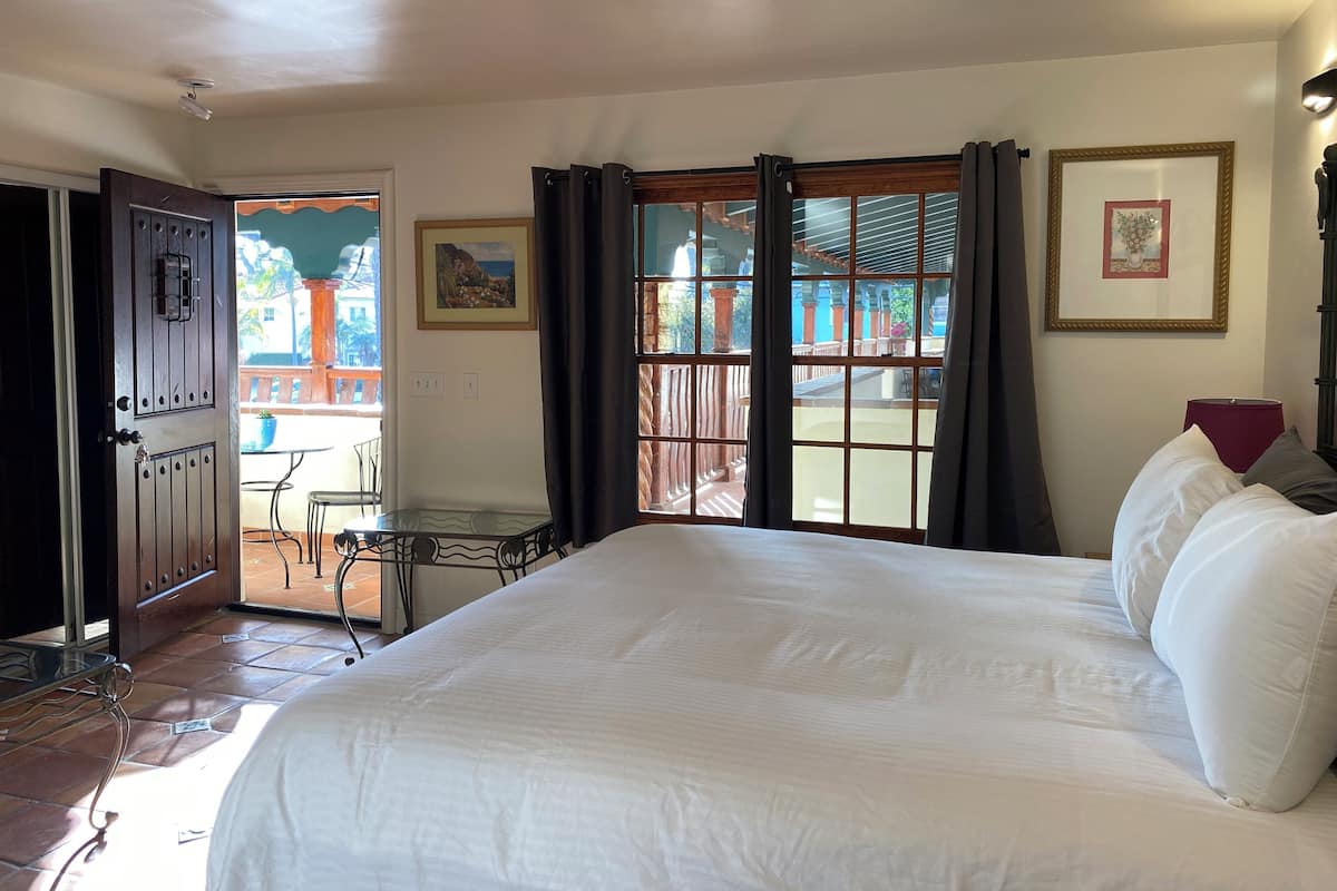 Ein Hotelzimmer mit einem großen Bett, einem Esstisch und Stühlen vor dem Fenster.