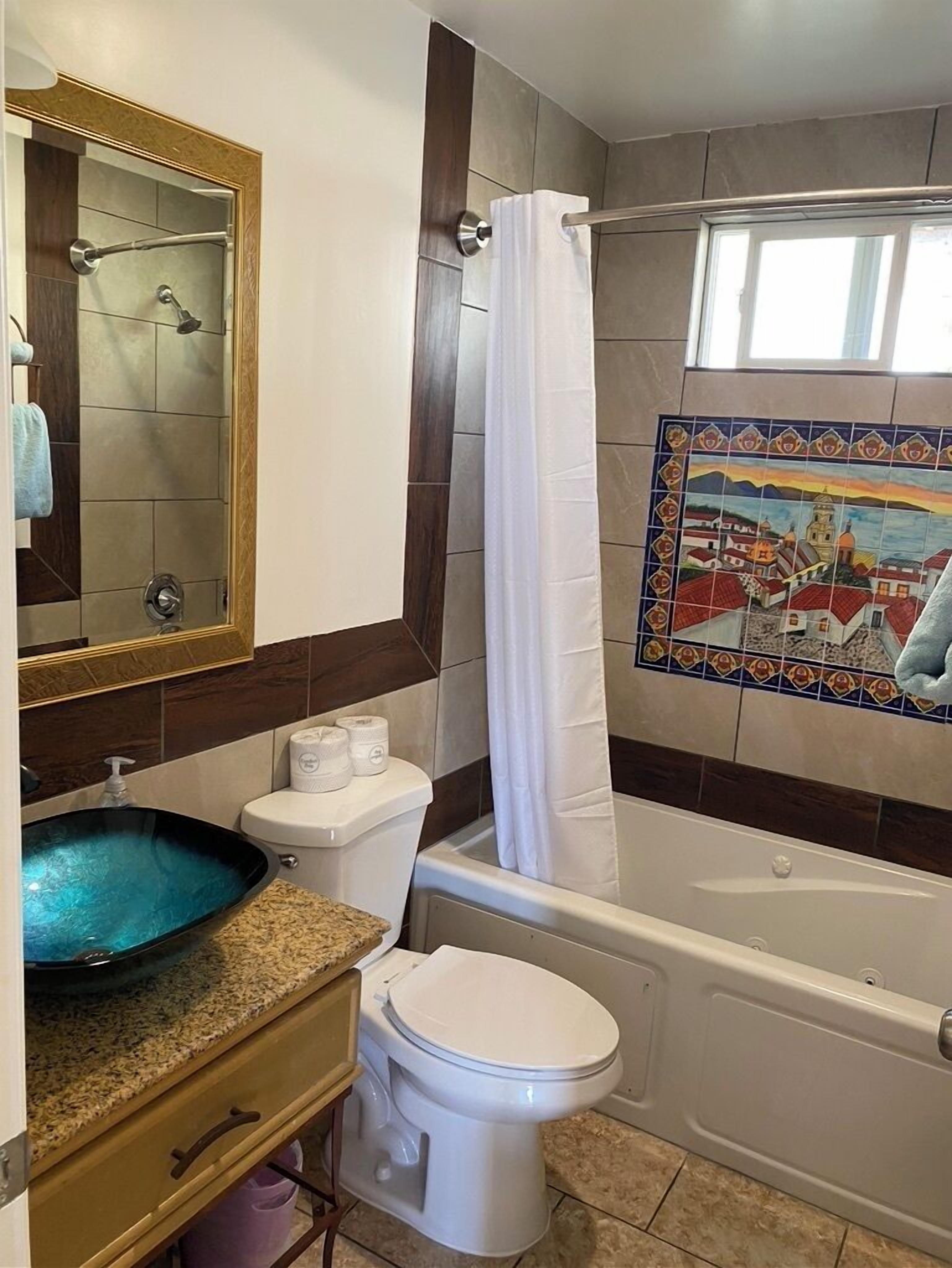 A bathroom with a bathtub, toilet, sink, and a shower with a glass door.