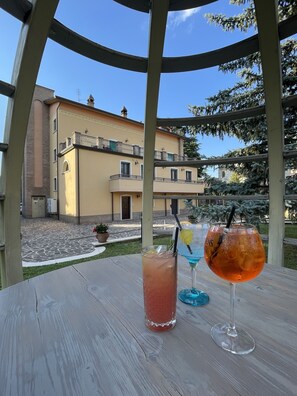 A wooden table with two drinks and a view of a building with balconies. - Luxury Apartment, strategic location, about 5 minutes from the historic center. (Perugia)