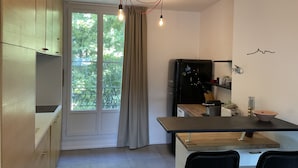 Una cocina moderna con comedor, ventanas amplias y vistas a zonas verdes.