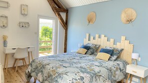 Een slaapkamer met een bed, bureau en stoel.