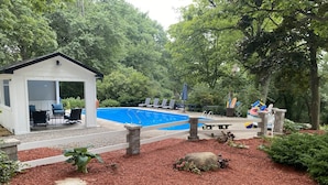 Ein Garten mit Pool, Liegestühlen und einem kleinen Schuppen.