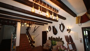 A room with a staircase, wooden beams, and hanging light fixtures. - Hotel Kreuz Höhengasthof (Breitnau)