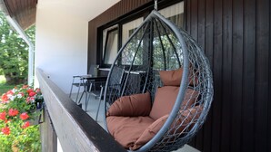 A hanging chair with cushions on a balcony. - Hotel Kreuz Höhengasthof (Breitnau)