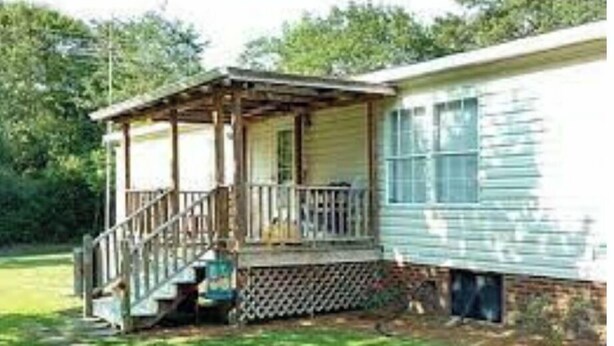 A two-story house with a porch and a small staircase leading to the upper level. - Family Home great for kids (Clinton)