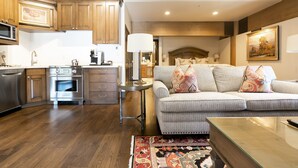 A modern kitchen with built-in appliances, a dining area with a glass coffee table, and a living room with a sofa and patterned rug. - Sterling One Bedroom Suite in Great location with Majestic Mountain Views 1 Condo by RedAwning (Park City)