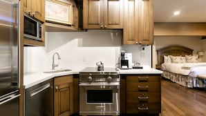 A compact kitchen with stainless steel appliances, wooden cabinets, and a small countertop. - Sterling One Bedroom Suite in Great location with Majestic Mountain Views 1 Condo by RedAwning (Park City)
