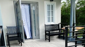 A covered porch with a bench, a door, and a window. - Carnbee Cozy Cottage (Carnbee)
