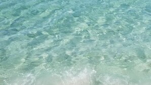 Een strand met helder ondiep water en een zandstrand.
