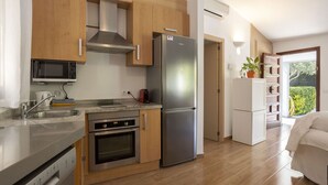 Une cuisine moderne dotée d’appareils électroménagers en acier inoxydable, de meubles en bois et d’un four encastré.