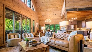 A spacious living area with a large wooden ceiling, a leather sofa, and a coffee table. - Playground|Views|Pets |Pool |Sauna |Massage Chair (Sevierville)