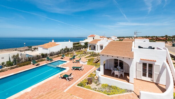A resort with a swimming pool, lounge chairs, and a view of the sea. - Rimar 4, 2 bedroom apartment, Cap d´Artrutx (Cala´n Bosch)