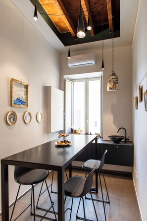 A modern kitchen with a central island, pendant lighting, and a view to the outside.