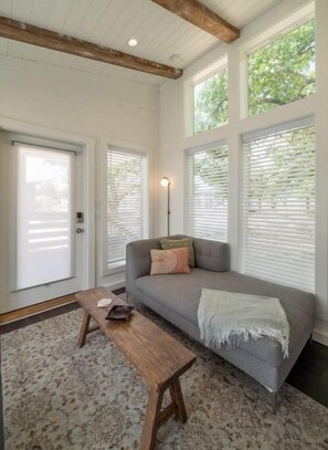 Relax in this inviting space with a comfortable sofa, wooden bench, and floor lamp.
