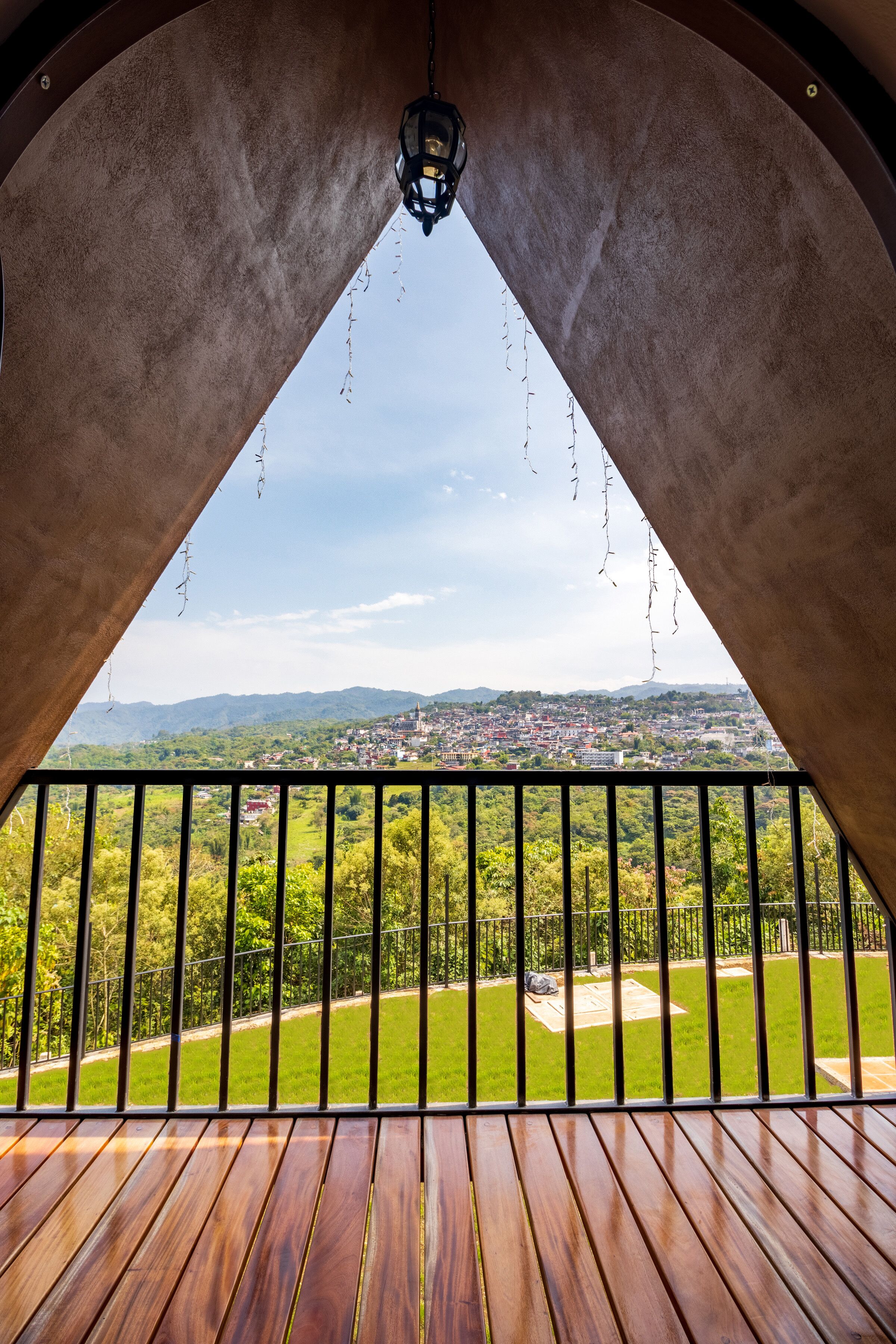 Una terraza de madera con vistas a un pueblo y montañas.
