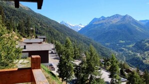 Una cabaña en la montaña con vistas a picos nevados.