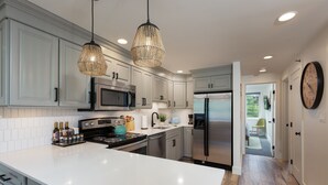 A modern kitchen with white cabinets, stainless steel appliances, and a large island. - Stunning & Modern Family-Friendly Slopeside Retreat in the Heart of Snowmass! (Snowmass Village)