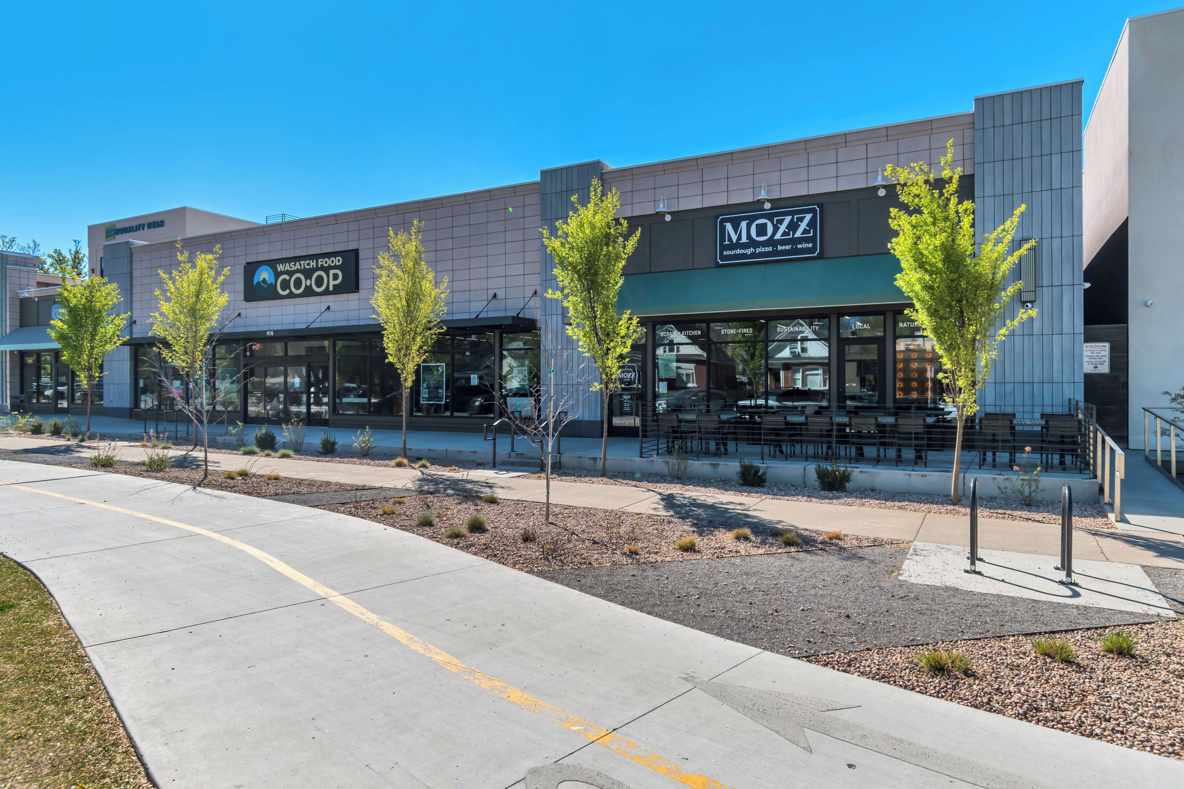 A modern building with Wasatch Food Coop and MoZZ restaurants.