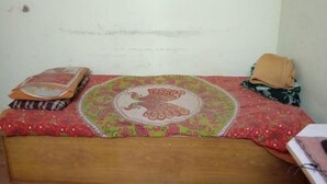 A bed with a floral bedspread and a decorative pillow.