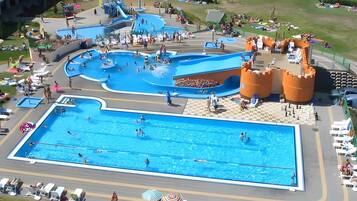A large outdoor swimming pool with multiple lanes and a water slide.
