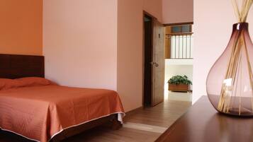 A bedroom with a wooden bed, a nightstand, and a vase.