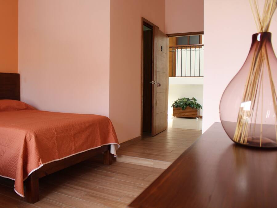 A bedroom with a wooden bed, a nightstand, and a vase.