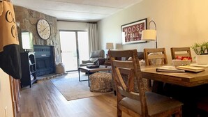 A cozy living room with a fireplace, a dining area with wooden chairs, and a sign that reads "MOOSE TRAIL". - Heart of the mountain/5 Beds/Peaceful location with large deck (Gatlinburg)