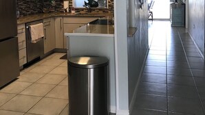Cocina moderna con electrodomésticos de acero inoxidable, una isla central y un amplio ventanal que proporciona luz natural.
