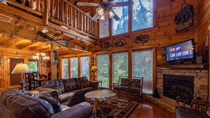Un acogedor interior de cabaña con chimenea, muebles de madera y televisor.