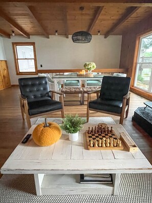 Enjoy a game of chess by the large window in this inviting room with a round table and comfortable seating.