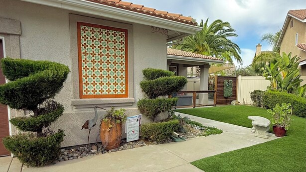 A residential property with a well-maintained lawn, a guest parking sign, and a tiled roof.