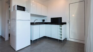 A modern kitchen with white cabinets, a black countertop, and a built-in microwave. - VILLA OASIS - APART N - 5 (TELDE)