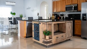 Una cocina moderna con armarios de madera, electrodomésticos de acero inoxidable y una isla central con pileta.