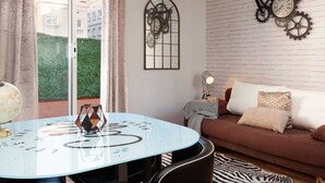 Ein Wohnzimmer mit einem runden Glastisch, einem braunen Sofa und einem Zebra-Teppich.